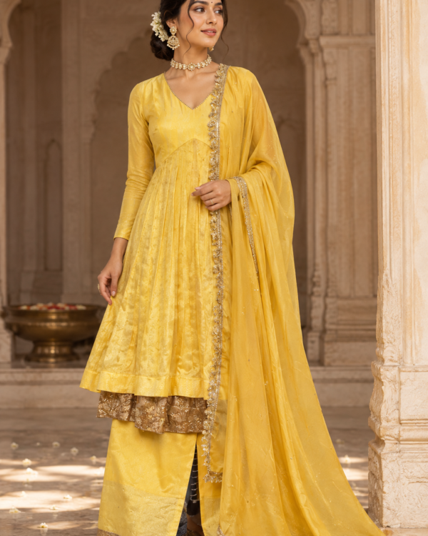 Indian model wearing a vibrant yellow Chanderi Anarkali with intricate Gota work detailing along the flare (dhera) by The Swamini by Sushmita.