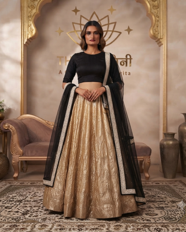 Model wearing a black long-sleeve embroidered blouse paired with a shimmering gold metallic lehenga skirt and black net dupatta by The Swamini by Sushmita.
