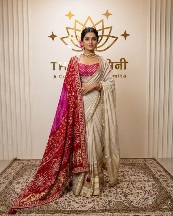 Model wearing an elegant off-white pre-draped saree paired with a vibrant pink blouse featuring intricate gold gota patti embroidery by The Swamini by Sushmita.