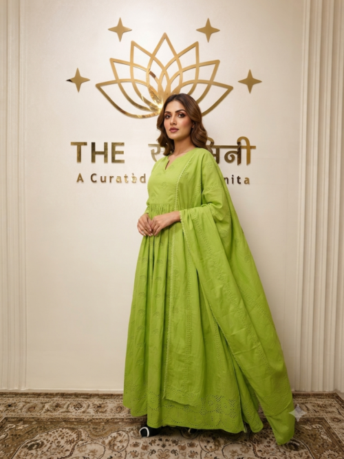 A model wearing a bright green Chikankari straight suit with matching palazzo and dupatta, posing inside a designer boutique.
