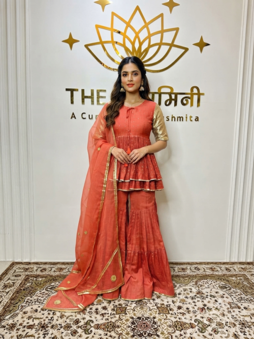 Indian model wearing a vibrant orange Chanderi peplum top paired with matching garara pants and a lightweight dupatta by The Swamini by Sushmita