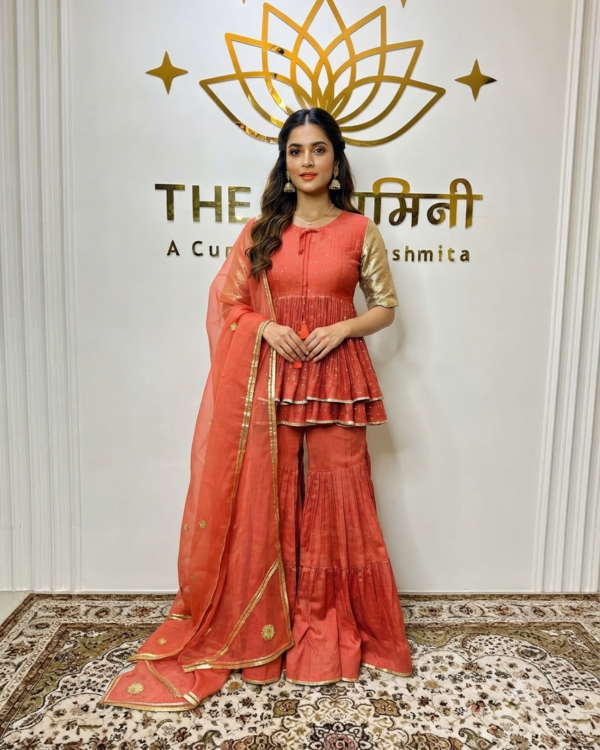 Indian model wearing a vibrant orange Chanderi peplum top paired with matching garara pants and a lightweight dupatta by The Swamini by Sushmita