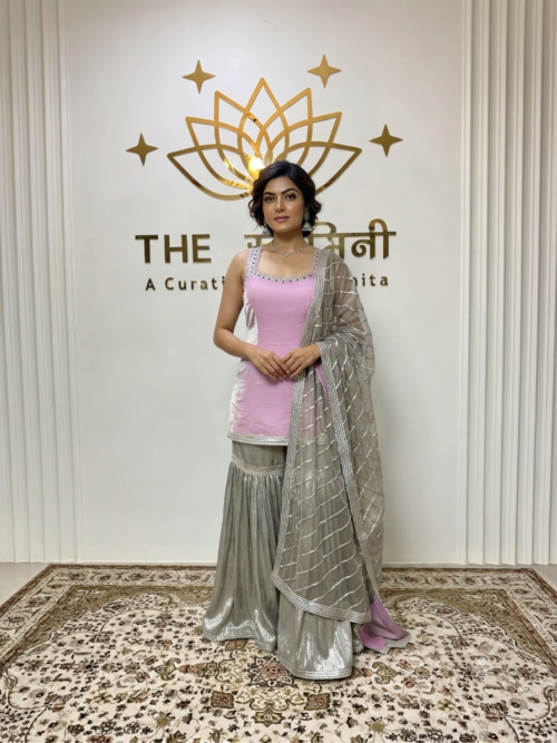 Indian model wearing a chic pink short kurti paired with a metallic silver garara and an embroidered gota work dupatta by The Swamini by Sushmita.