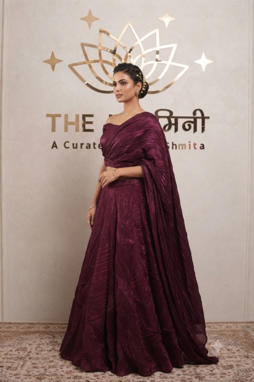 Model wearing a stunning maroon Indo-Western cape lehenga set with a matching crop top and flared skirt.