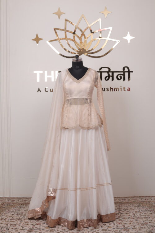 Ivory and gold Chanderi peplum top paired with flared lehenga and Mal Chanderi dupatta by The Swamini.