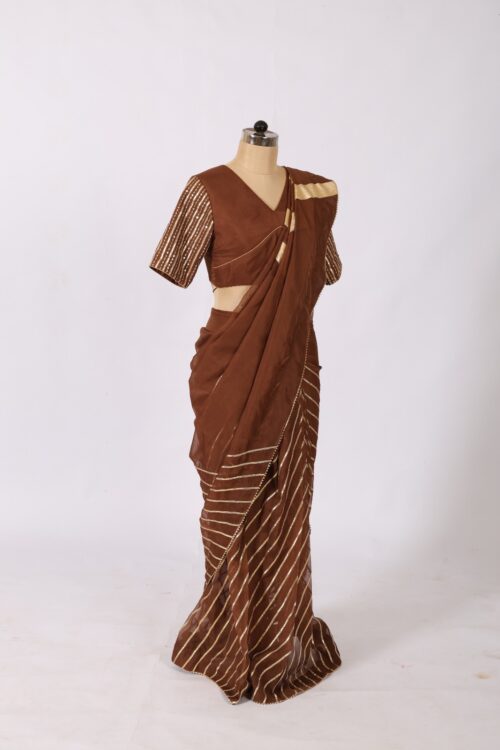 Draped brown ethnic saree showing heavy gold chevron gotta stripes across the chest and shoulder.
